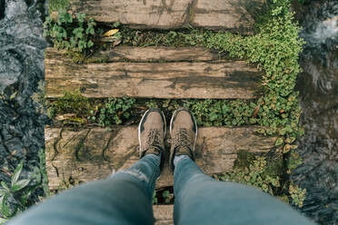 Point of view shot of woman standing on boardwalk above a brook on Sao Miguel Island, Azores, Portugal - AFVF06295