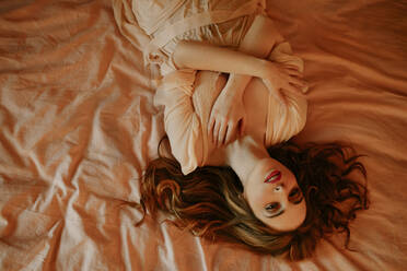 Porträt einer attraktiven blonden Frau im Bett liegend - GMLF00210