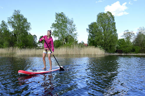 Frau beim Stand Up Paddling auf dem Staffelsee, Bayern, Deutschland - ECPF00919