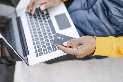 Close-up of man using laptop and credit card for online shopping stock photo