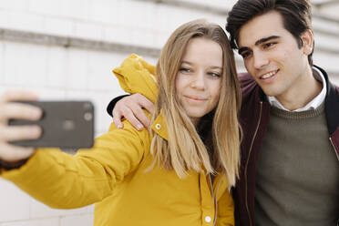 Porträt eines lächelnden jungen Paares, das ein Selfie macht - JCZF00103