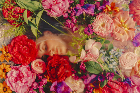Beautiful woman sleeping under glass pane with flowers - ERRF03815