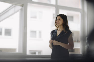 Portrait of smiling young businesswoman in a loft - JOSEF00753