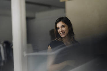 Portrait of smiling young businesswoman in a loft - JOSEF00754