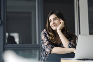 Portrait of daydreaming young freelancer in a loft - JOSEF00779