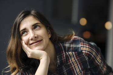 Portrait of smiling freelancer with head in hand looking up - JOSEF00804