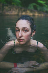Portrait of beautiful young woman bathing in hot spring, Caldeira Velha, Sao Miguel Island, Azores, Portugal - FVSF00281