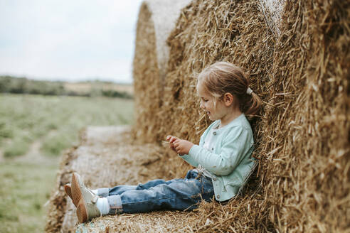 Kleines Mädchen sitzt auf Strohballen - VBF00069