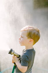 Little toddler boy playing with the garden hose - CAVF81559