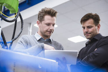 Two men using tablet in factory - DIGF10938