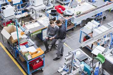 Two men using tablet in factory - DIGF10940