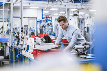 Mann mit Laptop in einer Fabrik - DIGF10947