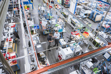 Two men having a meeting in factory examining product - DIGF10950