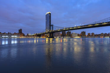 USA, New York, New York City, East River und Brooklyn Bridge in der blauen Morgendämmerung mit der Skyline von Manhattan im Hintergrund - LOMF01130