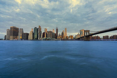 USA, New York, New York City, East River und Brooklyn Bridge in der Morgendämmerung mit der Skyline von Manhattan im Hintergrund - LOMF01132