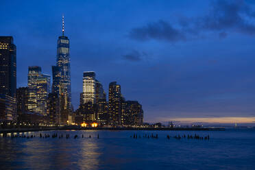 USA, New York, New York City, Hudson River at night with illuminated Manhattan skyline in background - LOMF01136