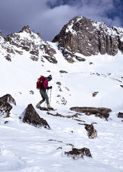 Frau beim Schneeschuhwandern in verschneiten Bergen im Winter in Montana - CAVF81866