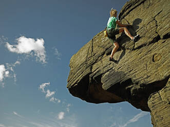 Man bouldering on grid stone in the Peak District / UK - CAVF81904