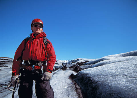 Älterer Mann bei der Erkundung des Gletschers Solheimajokull in Island, lizenzfreies Stockfoto