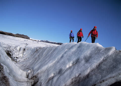 3 Männer bei der Erkundung des Gletschers Solheimajokull, lizenzfreies Stockfoto