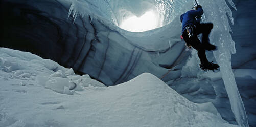 Eiskletterer erklimmt Eiszapfen in einer Höhle unter dem Langjokull-Gletscher - CAVF81946