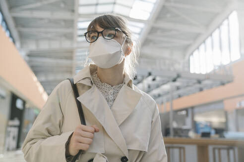 Portrait of woman wearing face mask in a shopping center - AHSF02602