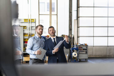 Zwei Geschäftsleute bei einem Treffen in einer Fabrik - DIGF11001