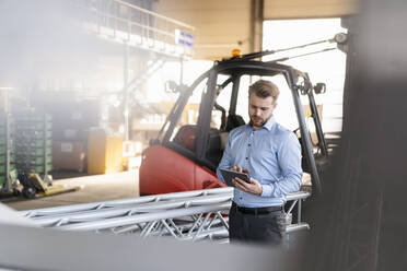 Junger Geschäftsmann benutzt Tablet in einer Fabrik - DIGF11007