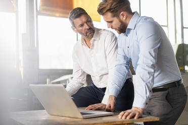 Two businessmen with laptop having a meeting in a factory - DIGF11020