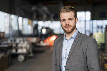 Portrait of a confident young businessman in a factory - DIGF11030