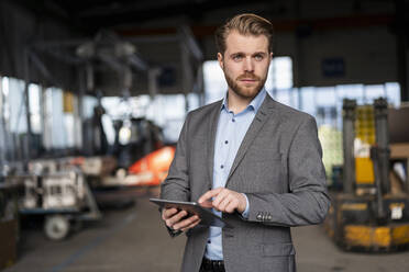 Porträt eines jungen Geschäftsmannes mit Tablet in einer Fabrik - DIGF11034