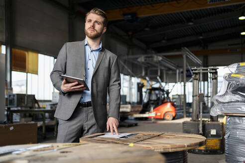 Junger Geschäftsmann mit Tablet in einer Fabrik - DIGF11039