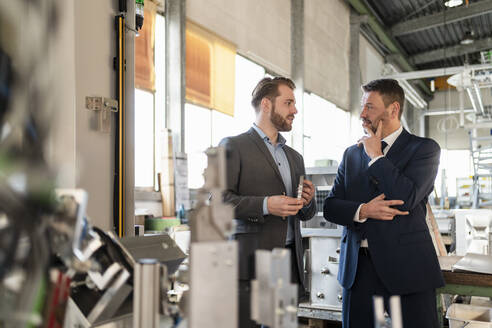 Zwei Geschäftsleute bei einem Treffen in einer Fabrik - DIGF11051