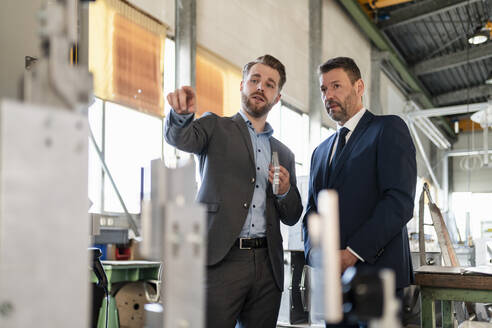 Zwei Geschäftsleute bei einem Treffen in einer Fabrik - DIGF11052