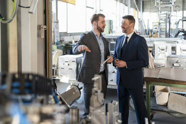 Zwei Geschäftsleute bei einem Treffen in einer Fabrik - DIGF11053