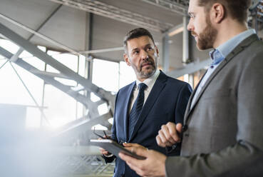 Two businessmen with tablet having a meeting in a factory - DIGF11065