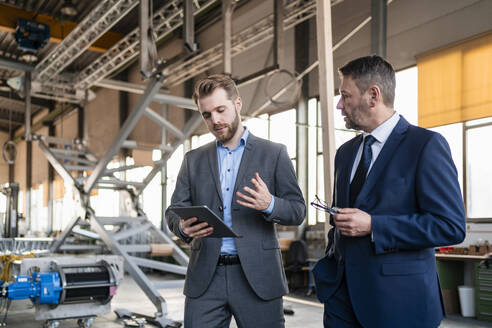 Zwei Geschäftsleute mit Tablet haben eine Sitzung in einer Fabrik - DIGF11074