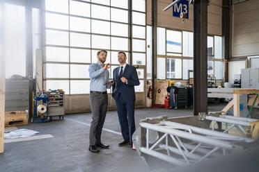 Two businessmen having a meeting in a factory - DIGF11076