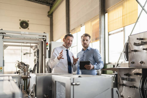 Zwei Geschäftsleute mit Tablet haben eine Sitzung in einer Fabrik - DIGF11087