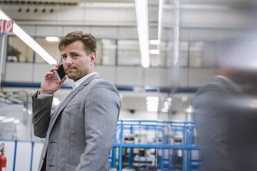 Businessman on the phone in a factory - DIGF11103