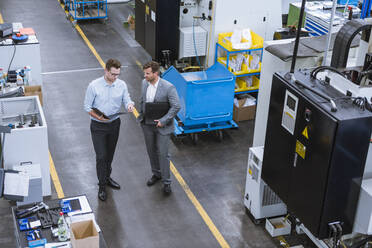 Two businessmen with clipboard talking in factory - DIGF11120