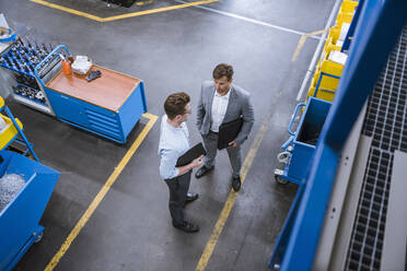 Top view of two businessmen talking in factory - DIGF11124