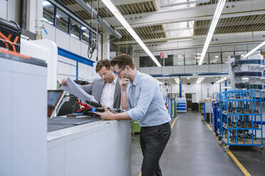 Two businessmen discussing a plan in a factory - DIGF11130