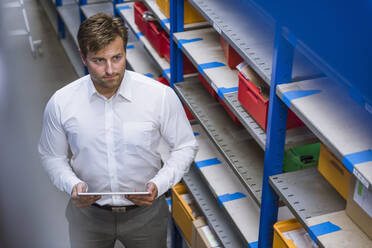 Man holding tablet in storehouse of a factory - DIGF11139