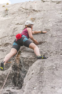 Junge Frau beim Klettern am Fels - FVSF00302