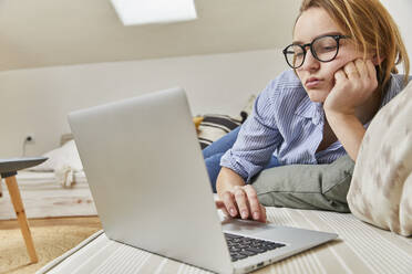 Portrait of bored young woman using laptop at home - FSF01087