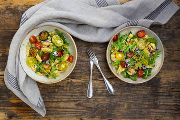 Two bowls of pasta salad with grilled zucchini, tomatoes, arugula, Spanish onion and balsamic vinegar - LVF08896