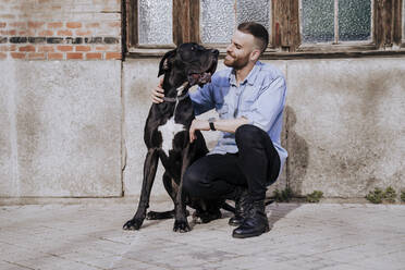 Smiling man with his dog outdoors - EBBF00101