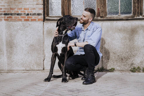 Lächelnder Mann mit seinem Hund im Freien - EBBF00101