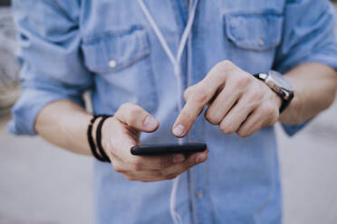 Crop view of young man using smartphone - EBBF00115